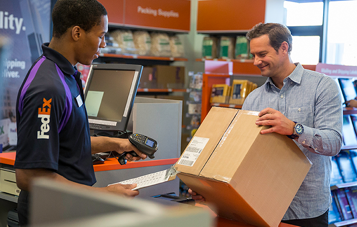 Need to Make a Return? A customer shipping a large box at a FedEx center