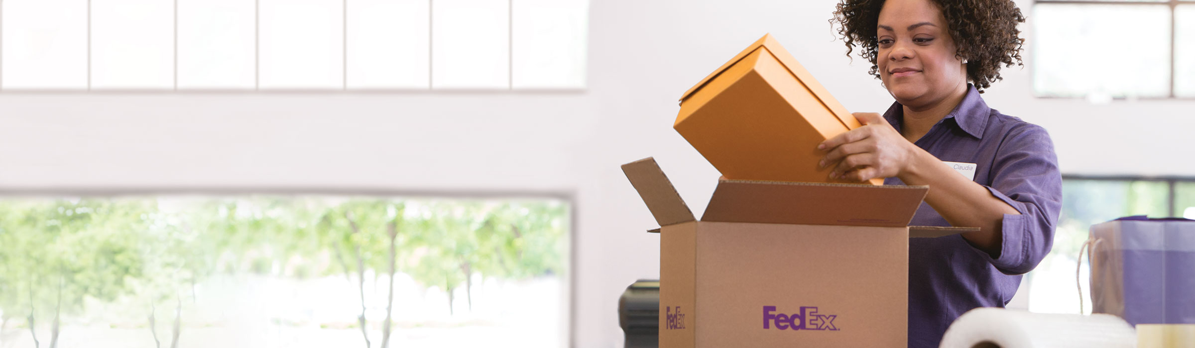 FedEx Office associates packing an iteminto a FedEx box in-store