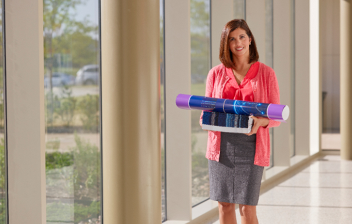 Woman in office space with a rolled up banner