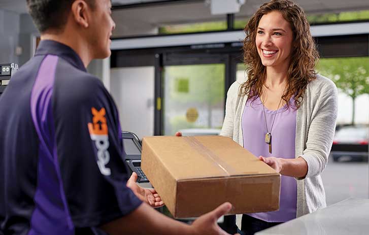FedEx employee helping customer with package