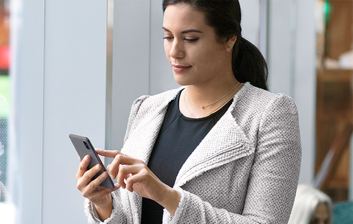 A woman using FedEx Delivery Manager on a smart phone
