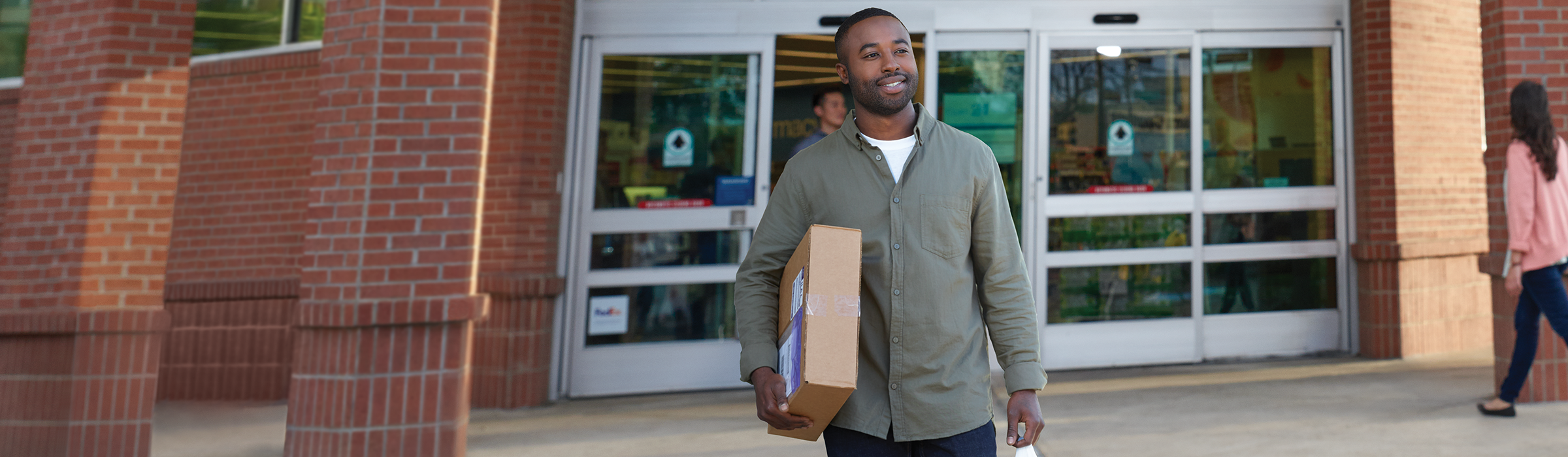 Customer walking out of Walgreens with a package