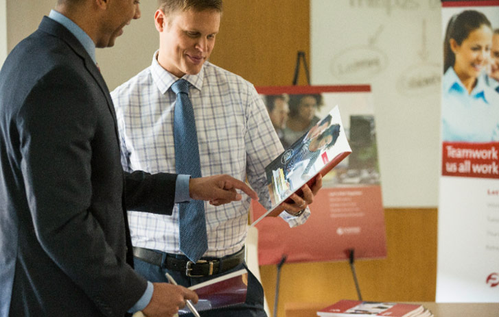 Explore the Possibilities Employee reviewing a presentation booklet