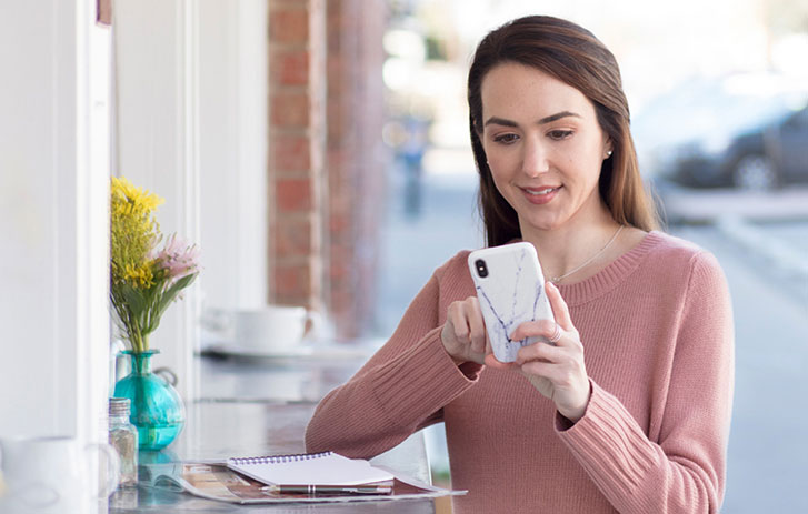 A customer using her phone to request to redirect her package
