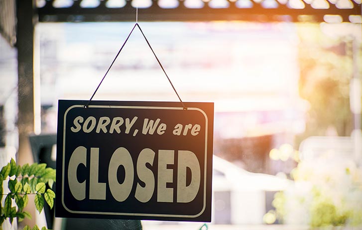 Black and white closed sign in store window