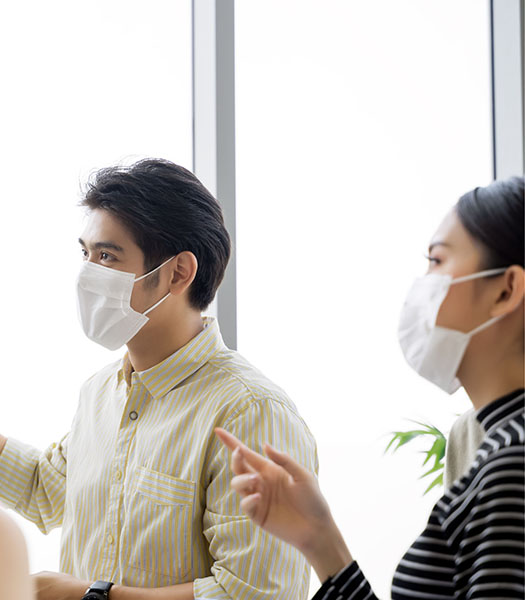 Two colleagues in masks pointing
