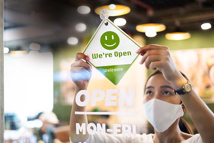 Woman hanging store Open sign