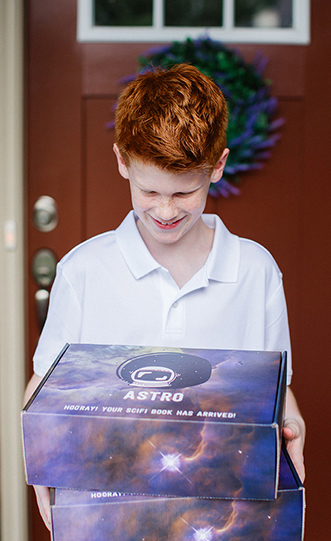 A child receiving a outer space themed custom branded box.