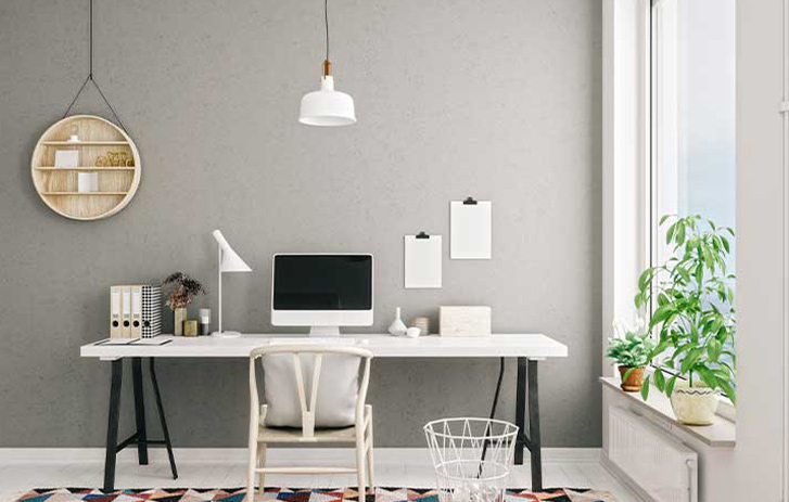 Open modern home office with plants and decorations on wall
