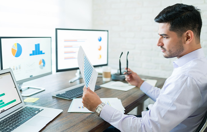 Male entrepreneur looking at website traffic on computer screen Male entrepreneur looking at website traffic on computer screen