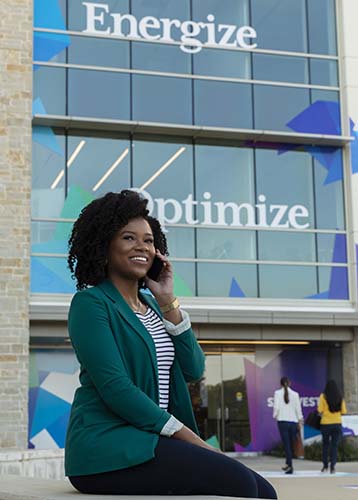Woman on cell outside building signs