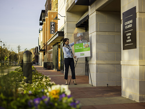 Woman adjusting outdoor sign
