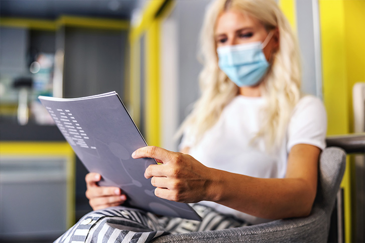 masked woman reading