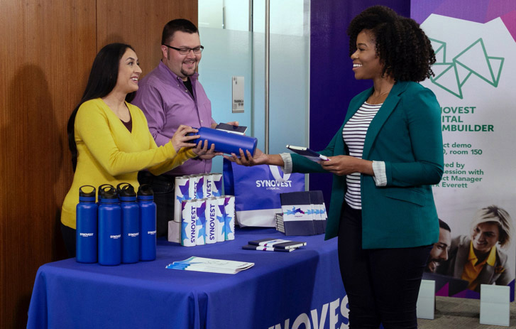 A person handing out promotional products at a trade show A person handing out promotional products at a trade show
