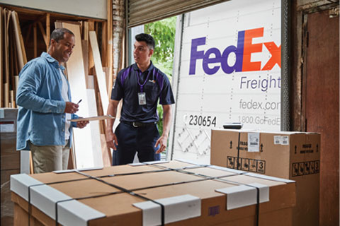 FedEx Freight employee and customer reviewing shipment