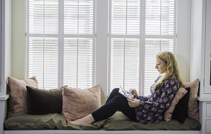 woman on couch by window