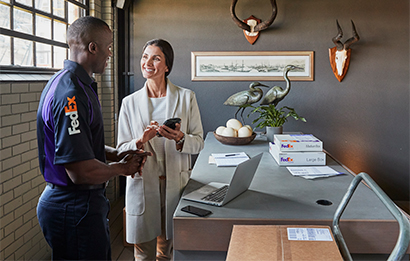 A customer works with a FedEx employee to process an international return package