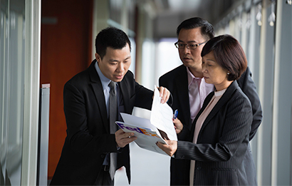 A real estate agent reviews documents with his clients
