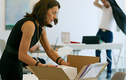 A businesswoman places a return item in a FedEx box
