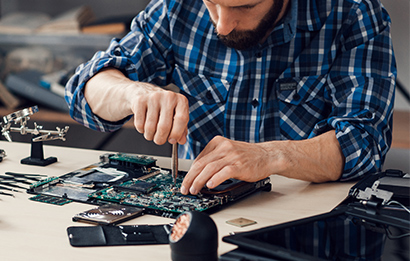 A man repairs a laptop motherboard