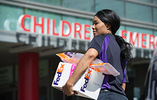 A FedEx courier delivers supplies to a Children's Hospital.