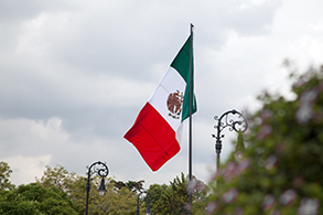 Low-angle view of Mexican flag flying over the Palacio Nacional in Mexico City