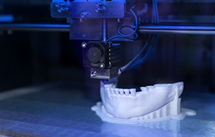 Close up of a human's lower jaw bone being created by a 3D printer