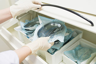 Close up of medical instruments in metal trays sealed in separate sterile plastic bags.