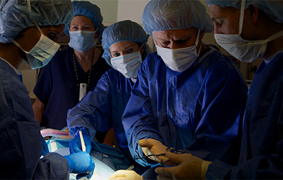 A team of medical professionals performs a surgical procedure.