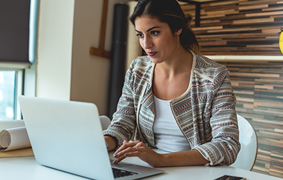 A young woman checks information on her laptop