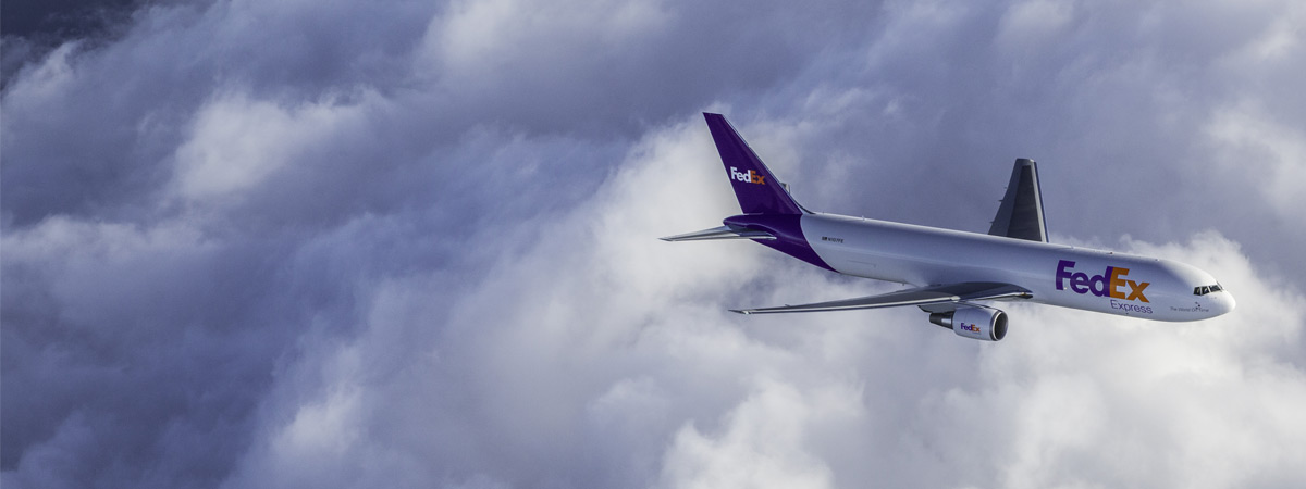 Airport staff helping load items onto FedEx plane