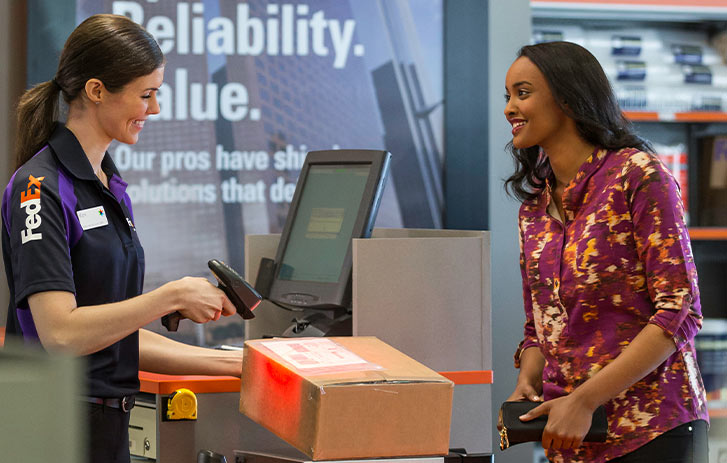 fedex worker scanning package for customer