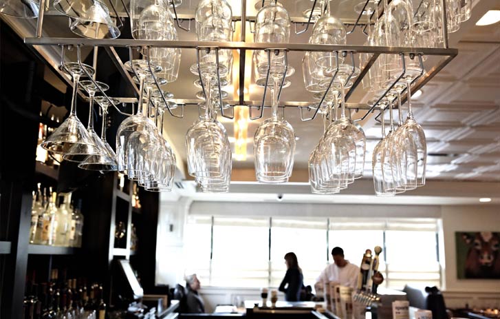 A photo of wine glasses hanging over the bar in a restaurant