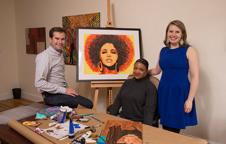 A photo of Spencer and Liz Powers from ArtLifting with one of their artists who is painting a portrait