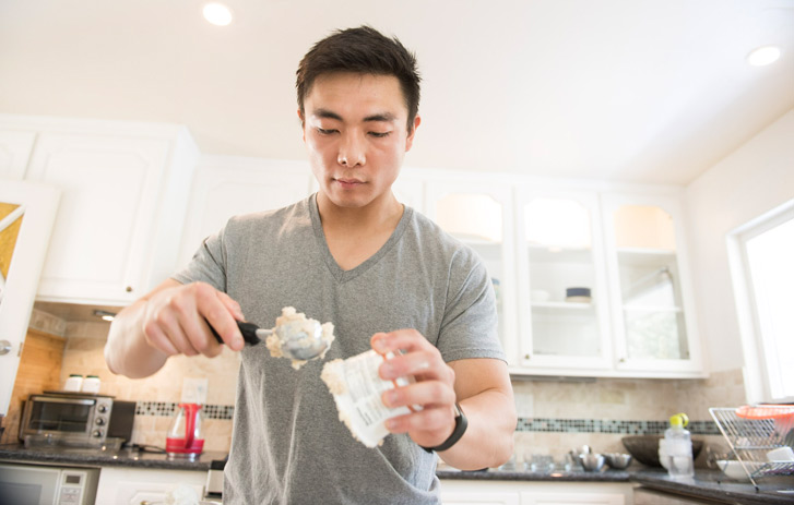 A photo of Yang Bai scooping Flexfrost ice cream in a kitchen