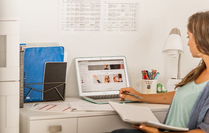 FedEx Small Business Grant Winner A photo of Kat Samardzija of Locker Lifestyle looking at a laptop in her office