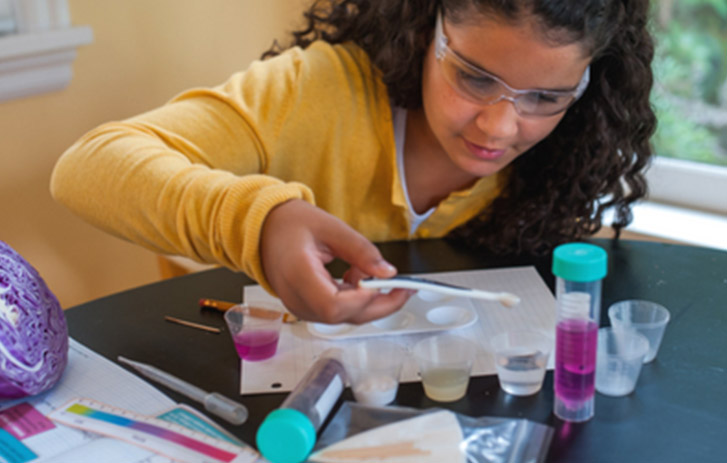 A photo of a girl using her Yellow Scope chemistry kit.