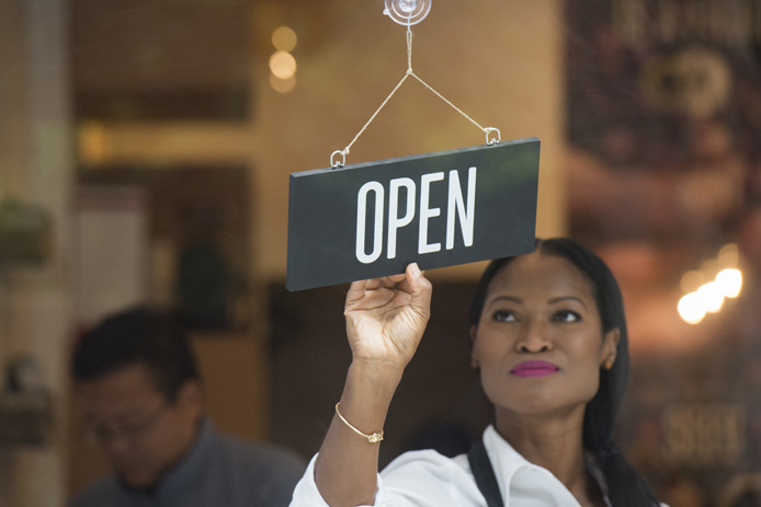 store employee flipping open sign over
