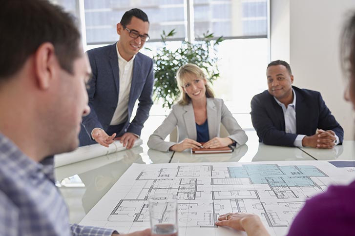 Four people at table in office conference room