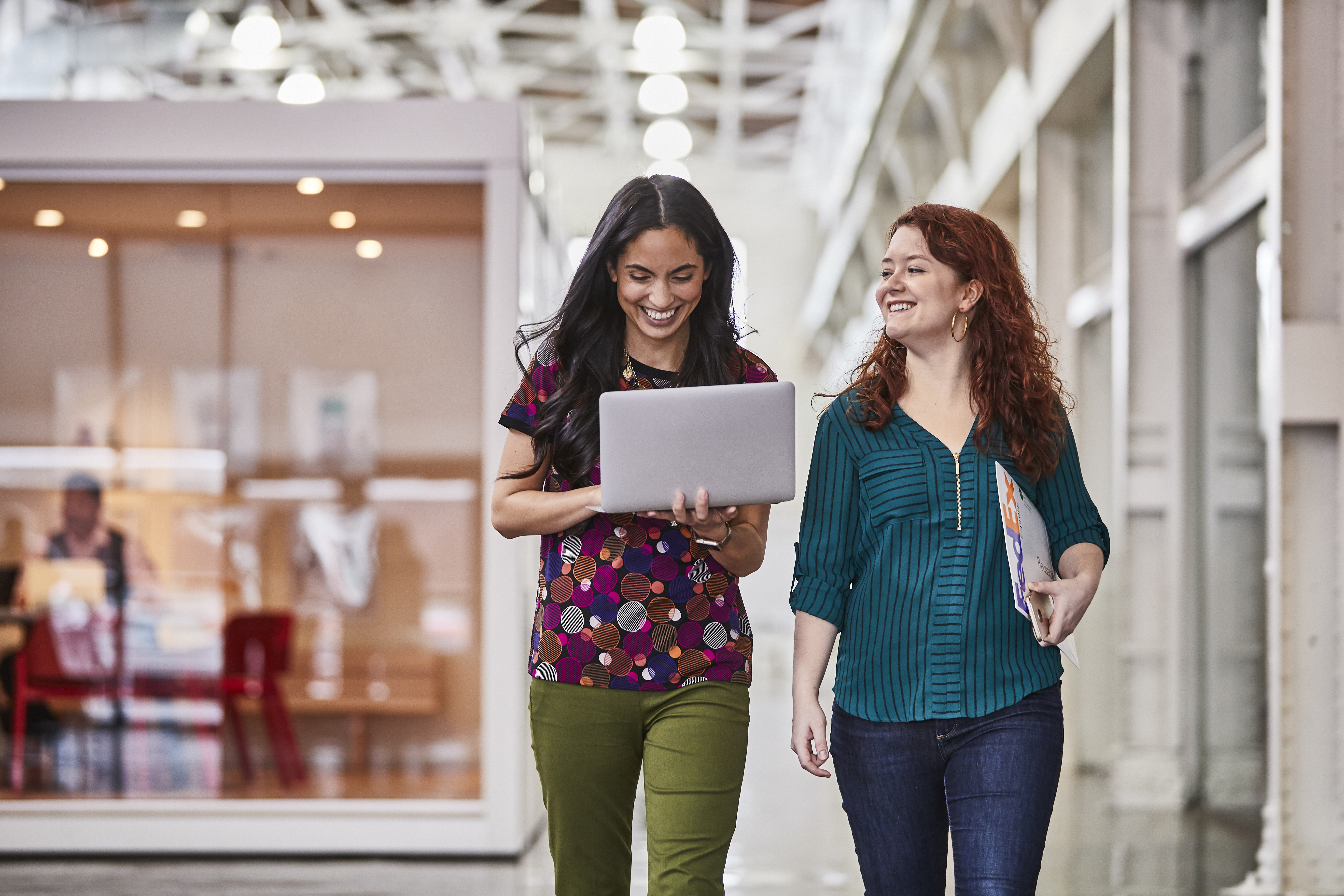 Two female colleagues looking at laptop in office setting