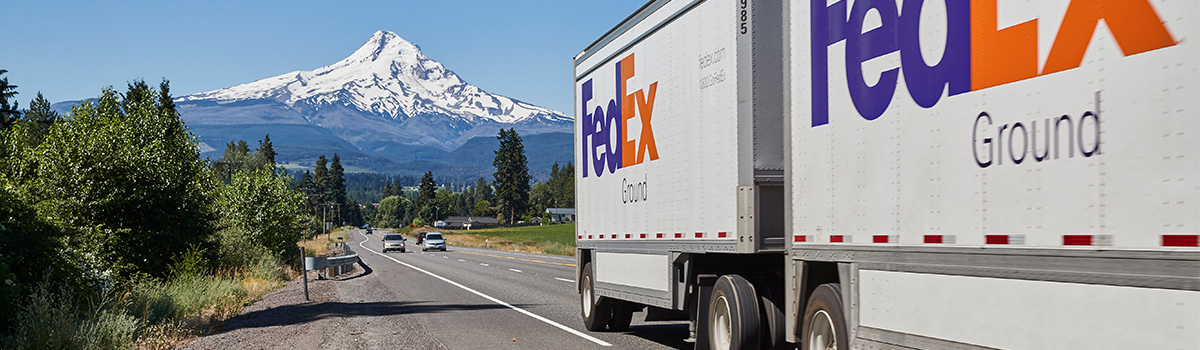 FedEx Ground truck on mountain road.
