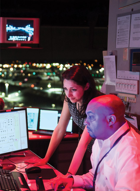 A man and woman in an office looking at a computer screen