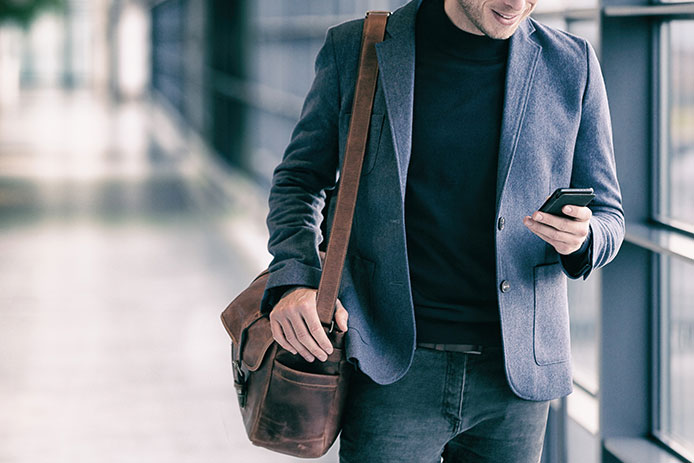 Man looking at a mobile phone while walking.