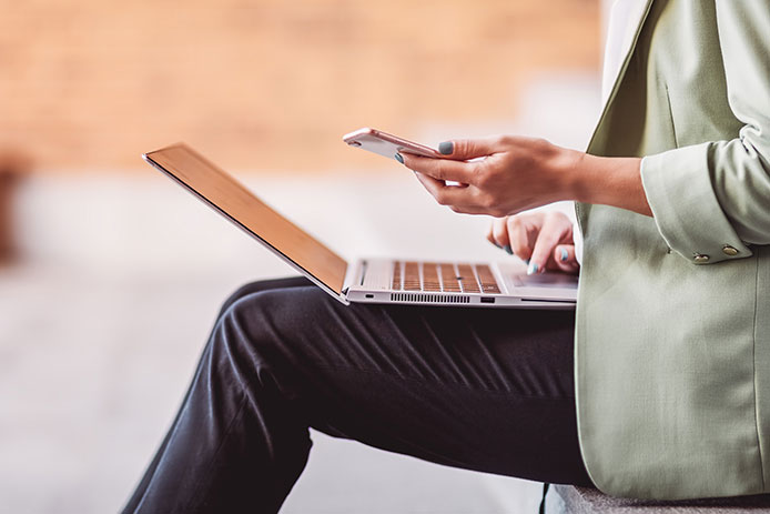 Woman on laptop and mobile phone.