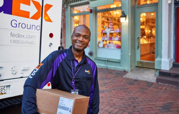 A FedEx team member holding a package.