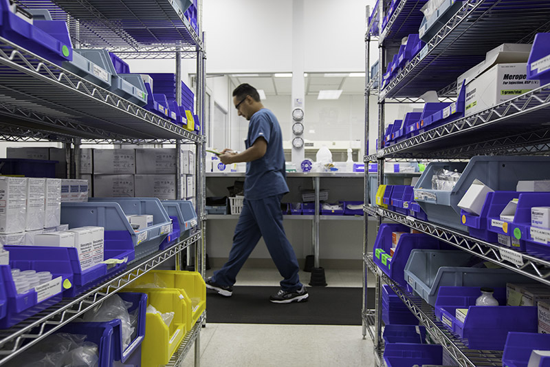 A nurse walks through a supply closet