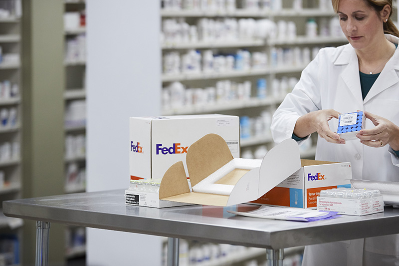 Woman in lab coat shipping with FedEx