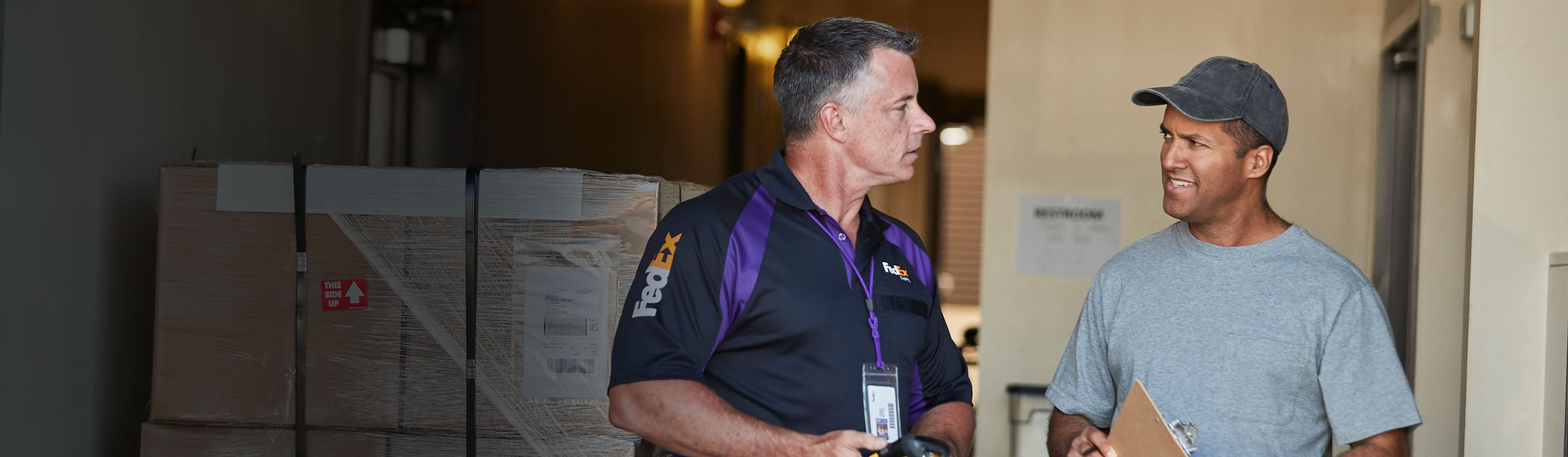 FedEx Employee talking to another man inside warehouse