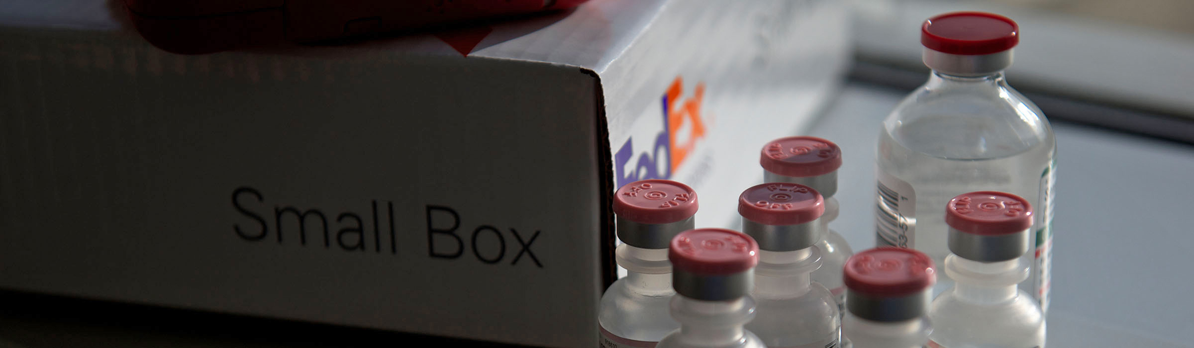 Several small vials next to FedEx box
