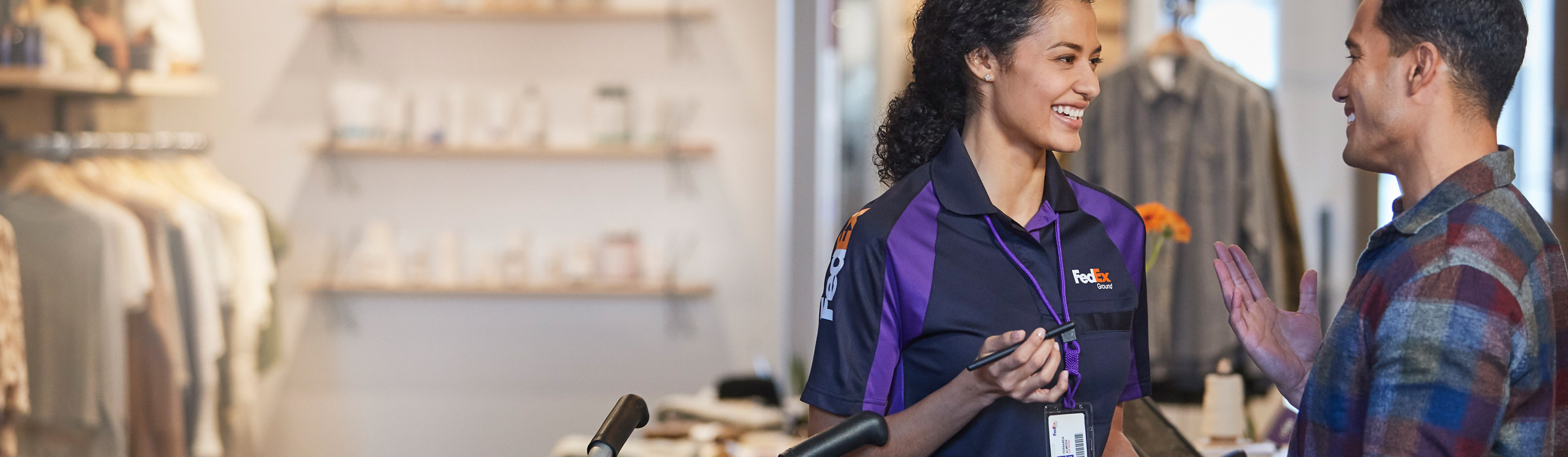 FedEx Courier standing with woman scanning packages for pickup